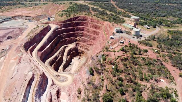 Aerial drone mining pit open cut copper ore mine with water tank bushland red rock travel industry tourism Fort Bourke Hill Cobar NSW Australia outback 4K