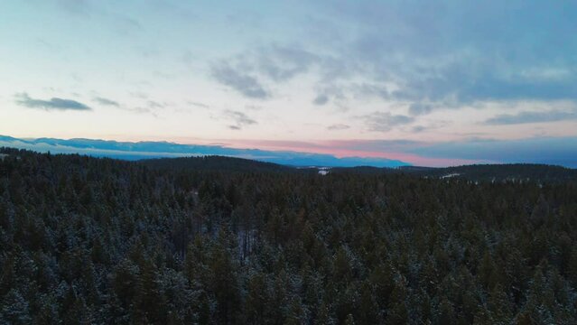 The Splendor of the Canadian Rocky Mountains: A Sunset Aerial Tour of a Snowy Forest