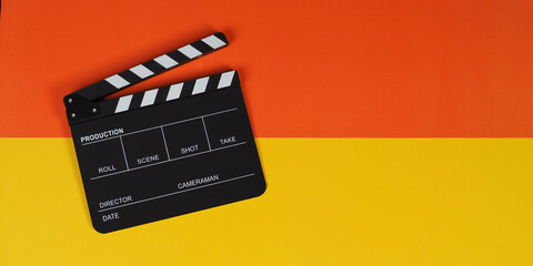 Fototapeta na wymiar Clapper board or movie slate on yellow and orange background.
