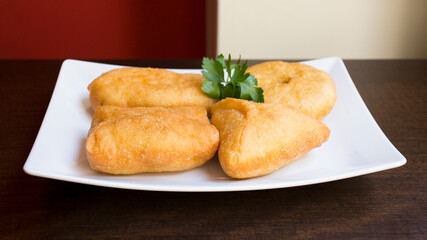Pirozhki​ are stuffed rolls typical of Russian, Belarusian, and Ukrainian cuisines. They can be baked or fried with yeast. Their fillings are made of meat or vegetables.
