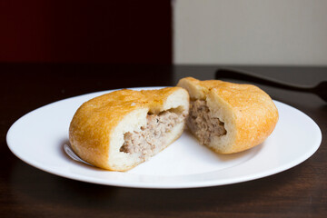 Pirozhki​ are stuffed rolls typical of Russian, Belarusian, and Ukrainian cuisines. They can be baked or fried with yeast. Their fillings are made of meat or vegetables.