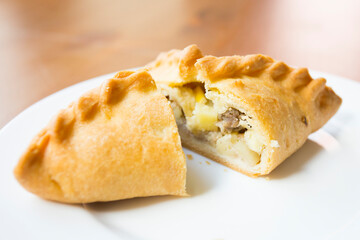 Pirozhki​ are stuffed rolls typical of Russian, Belarusian, and Ukrainian cuisines. They can be baked or fried with yeast. Their fillings are made of meat or vegetables.