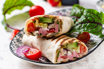 Tortilla wrap with ham, cheese and tomatoes on a white background. Shawarma.