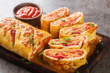 Delicious pizza stromboli roll stuffed with salami sausage and mozzarella cheese close-up on a...