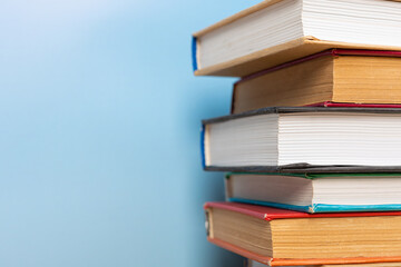Stack of books in the colored cover lay on blue backround. Education learning concept