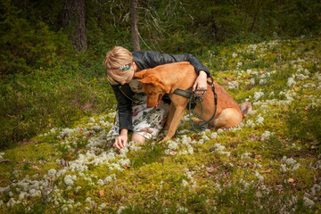 Owner with brown dog in spring wood scenic photography. Picture of person with woodland on background. High quality wallpaper. Photo concept for ads, travel blog, magazine, article