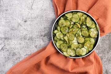 Japanese Cucumber Salad - Sunomono on a round plate on a dark background. Top view, flat lay