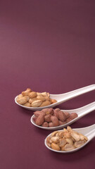 Close up of Salted Peanuts Indian namkeen (snacks) on a ceramic white bowl. Top view