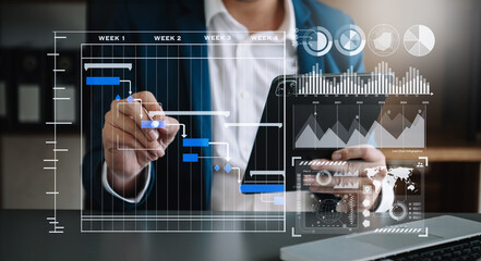 Businessman hand Project manager working and update tasks and Gantt chart scheduling virtual diagram.with smart phone, tablet and laptop .