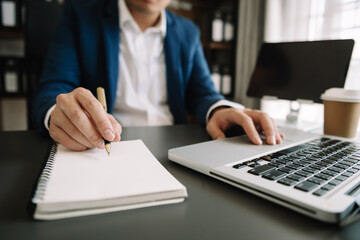 Obraz premium businesswoman hand working with new modern computer and writing on the notepad strategy diagram as concept morning light..