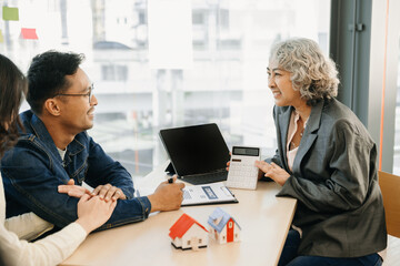 Fototapeta premium Real estate broker agent presenting and consult to customer to decision making sign insurance form agreement, home model, concerning mortgage loan offer