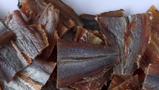 Dried fish fillet red cod amber. An appetizer for beer in full background, slow motion close-up.