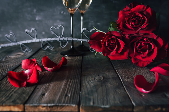 Valentines day decoration with red roses and champagne. Vintage still life for love and background for mother's day greetings.
