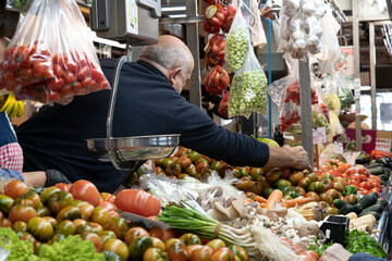 Man selling tomatoes at market stall