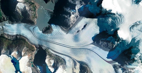 aerial view of glacier between rocky and snowy mountains
