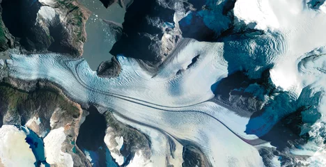 Fototapeten aerial view of glacier between rocky and snowy mountains © benjamin