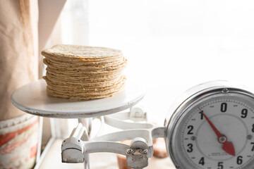 One kilo of corn tortillas are on the weighing analog scale. Close up