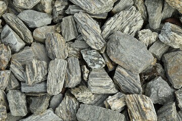 Grey decorative stones as background, top view