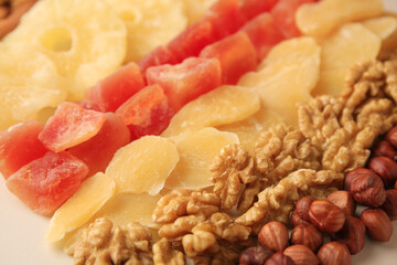Different tasty nuts and dried fruits on beige background, closeup