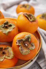 Bowl with delicious ripe juicy persimmons, closeup