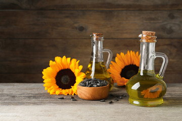 Fototapeta na wymiar Sunflower cooking oil, seeds and yellow flowers on wooden table