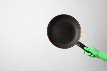 Woman holding empty frying pan on white background, closeup. Space for text