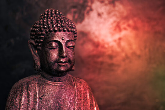 Meditating Buddha Statue isolated on dark background. Copy space.