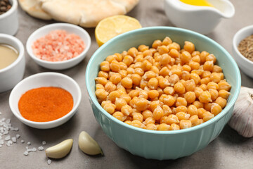 Delicious chickpeas and different ingredients on light grey table, closeup. Cooking hummus