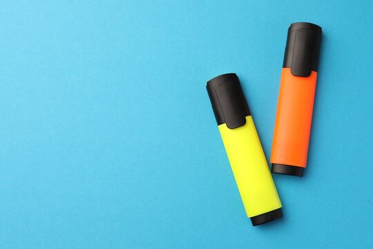 Bright markers on light blue background, flat lay. Space for text