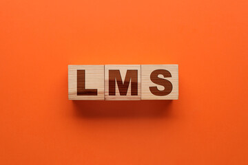 Learning management system. Wooden cubes with abbreviation LMS on orange background, top view