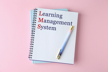 Fototapeta premium Notebook with text Learning Management System and red initial letters forming initialism LMS on pink background, top view