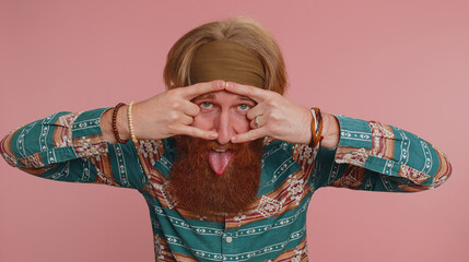 Rock n roll. Overjoyed delighted hippie man in pattern shirt showing gesture by hands, cool sign,...