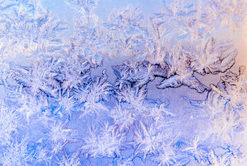 Frost patterns on a window in winter day (violet background)