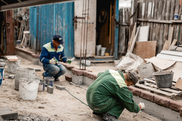 business, building, teamwork and people concept - group of smiling builders outdoors