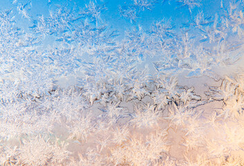 Frost patterns on the window in sunny winter day
