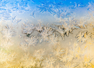 Frost patterns on the window in sunny winter day