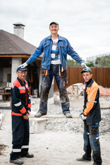 Obraz na płótnie Canvas business, building, teamwork and people concept - group of smiling builders outdoors