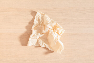 Brown tissue paper isolated on wooden background. Crumple toilet paper. Wooden surface. Paper texture. Brown tissue paper. Household. Clean. 