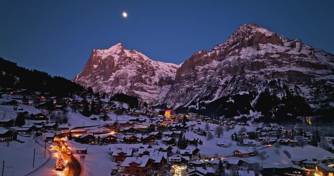 Panorama aerial Drone shot of Cottages chalets in Murren village at snowy winter night. M&uuml;rren traditional Walser mountain village in the Bernese Highlands of Switzerland. popular tourist spots.