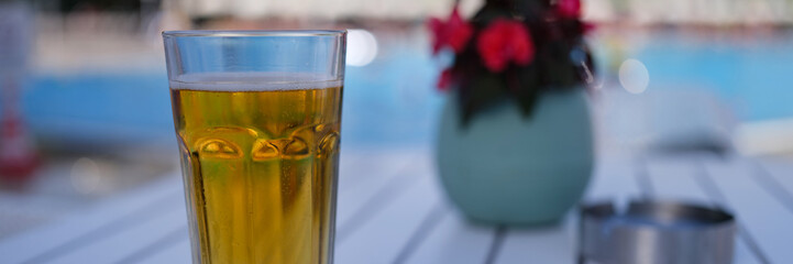Glass of tea or beer on table in evening