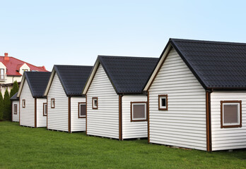 Obraz premium Beautiful wooden beach houses and green lawn outdoors