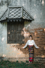 Tourist an Asian Thai woman dressed in traditional Thai dress at the old house in Lampang,...