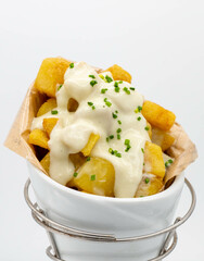 Cono de patatas fritas españolas con salsa picante, para llevar.