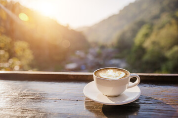 Cup of coffee on wooden table at sunset, sunset nature background nature concept.