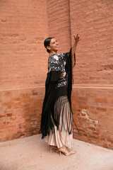 Portrait of a woman dancing, wearing a spain traditional outfit with a black shawl