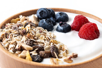 Yogurt with berries and muesli for breakfast in bowl. Close up