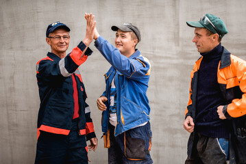 business, building, teamwork and people concept - group of smiling builders outdoors