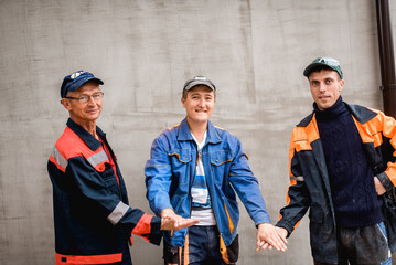 business, building, teamwork and people concept - group of smiling builders outdoors