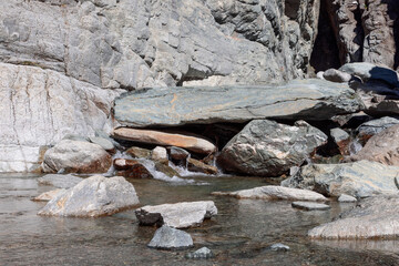 Pond with crystal clear running water and small pebbles and sands formed by Lillaz waterfall (Cascate di Lillaz) in Gran Paradiso National Park, Aosta valley, Italy