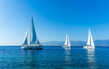 Obraz na płótnie Canvas sailing yacht boats with white sails in blue sea , seascape of beautiful ships in sea gulf with mountain coast on background